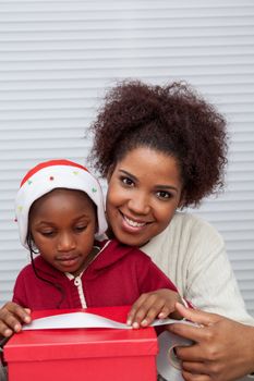 30-35, 4-6, african, apartment, attractive, beautiful, black, box, bun, child, christmas, couple, curly, daughter, decorating, family, female, gift, girl, girls, happy, hat, holding, home, homey, house, household, life, living, love, model, mother, offering, old, parent, person, pretty, property, releases, ribbon, room, sitting, two, vertical, woman, years, young