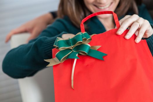 35-40, bag, beautiful, caucasian, celebrating, celebration, cheerful, christmas, cute, decoration, female, festive, festivity, gift, hand, hands, happy, holding, holidays, horizontal, joyful, merry, model, old, one, open, opening, palm, person, present, pretty, property, red, release, ribbon, white, woman, years, green, neck