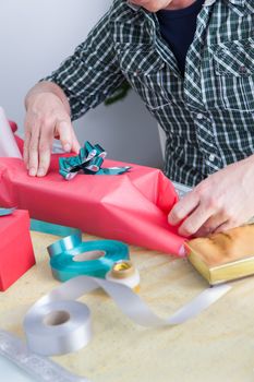 35-40, bow, box, bun, caucasian, celebrate, celebration, christmas, decor, decoration, gift, gifts, giving, green, greeting, hand, happy, holding, holiday, man, model, old, one, person, present, presents, property, red, release, ribbon, sitting, surprise, table, vertical, view, white, wrap, wrapped, wrapping, xmas, years