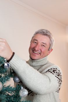 35-40, adult, at, ball, balls, camera, caucasian, celebration, christmas, cute, decorating, decoration, decorations, family, father, festive, fun, green, handsome, happiness, happy, holiday, home, house, looking, love, male, man, model, old, person, pine, property, release, smile, smiling, tradition, traditional, tree, vertical, white, x-mas, xmas, years