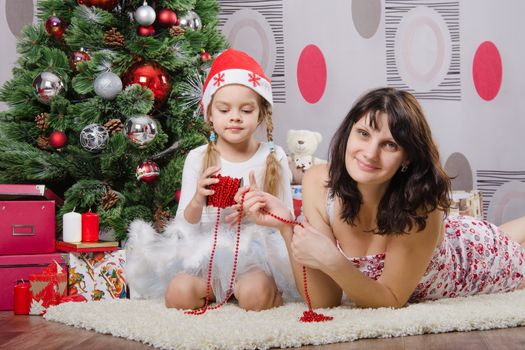 Mum and daughter lie on the five-year rug Christmas tree