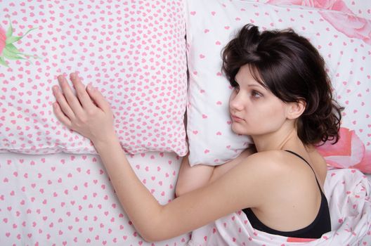 Young beautiful girl sleeping alone in bed