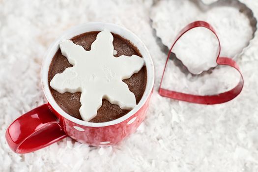 Above shot of a vibrant red cup of hot chocolate with snow flake shape of whipped cream. Extreme shallow depth of field.