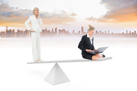 White scales weighing businesswomen against cityscape on horizon