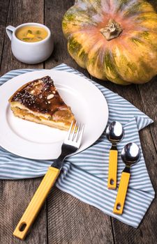 Pumpkin pie piece with cream soup on wood in Rustic style