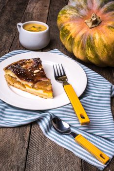 Pumpkin pie piece with cream soup on wood in Rustic style