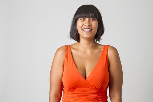 Mid-twenties filipino woman in low cut orange dress