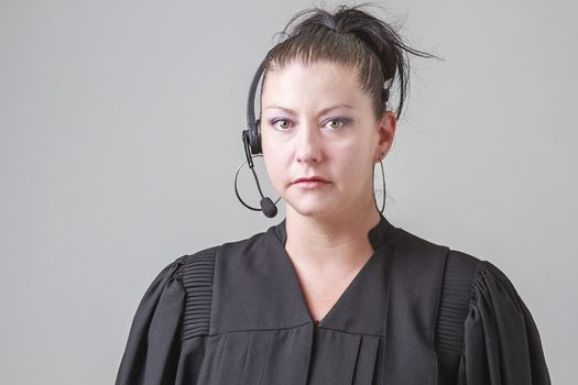 thirty something woman, wearing a preacher robe and phone headset