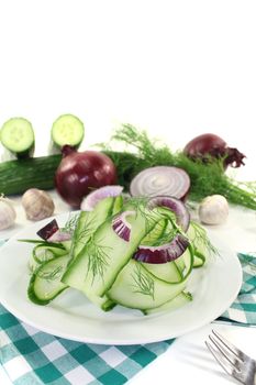 Cucumber salad with onions and dill on light background