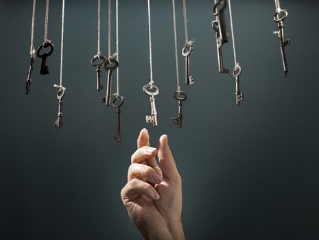 Hand choosing a hanging key amongst other ones.