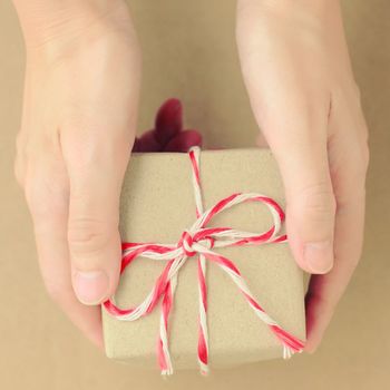 Hand holding gift box with retro filter effect