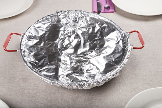 spanish paella in paellera pan wrapped with foil