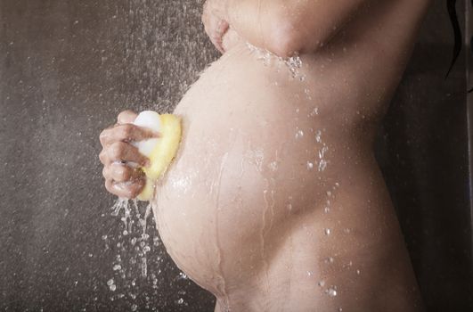 pregnant woman with white bikini under shower water