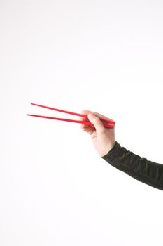 woman hand detail isolated with red chopstick on white background