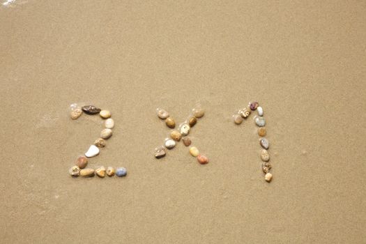 2x1 discount word writing with small stones on sand beach ground