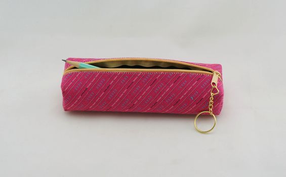 Pencil bag made of pink fabric, cylinder rod shape, inside had blue pencil.                               