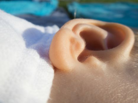 close-up baby ear with little hair  and blue towel