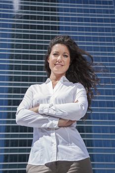 businesswoman cross armed pose in skyscrapers background