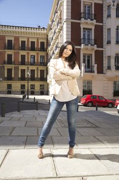 crossed arms brunette woman standing at street in Madrid city Spain
