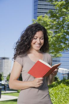 laughing woman reading a red book at street