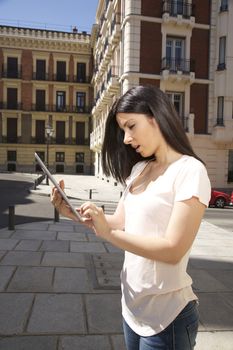 young woman touching a digital tablet at street in Madrid city Spain
