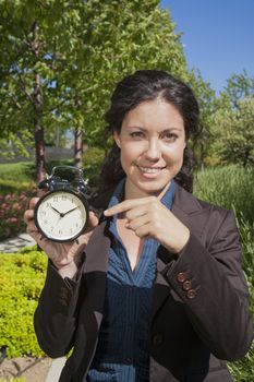 businesswoman with big clock in exterior background