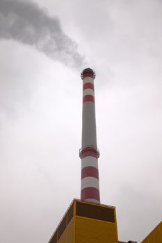 Industrial chimney smoking in the cloudy weather