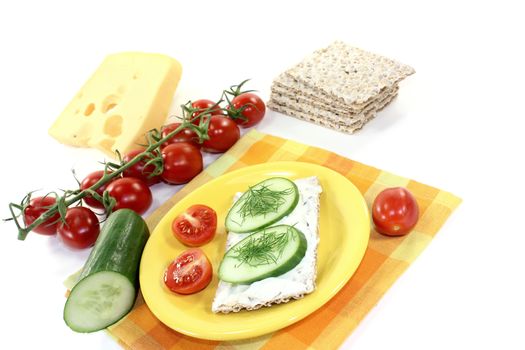 Crispbread with cream cheese and cucumber on a bright background