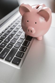 Piggy Bank Resting on Laptop Computer Keyboard.