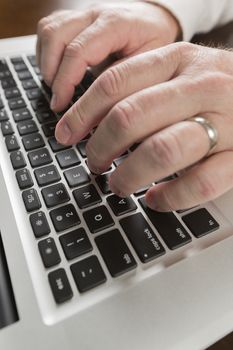 Male Hands Typing on Laptop Computer Keyboard.