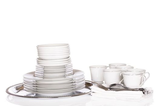 Dinnerware, stacks of white chinaware on silver platter