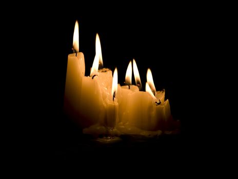 Group of white candles burning in the dark