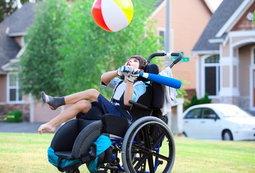 Disabled little boy playing ball in the park