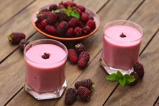 Freshly prepared blackberry milkshake in two glasses (Selective Focus, Focus on the blackberry on the first milkshake)