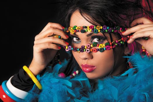 Woman holding colorful necklace of beads on his face.