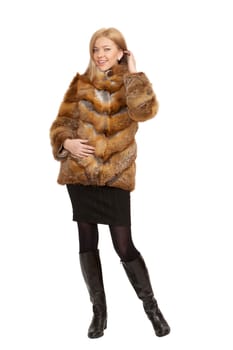 The blue-eyed blonde in a magnificent fur coat, it is isolated on a white background
