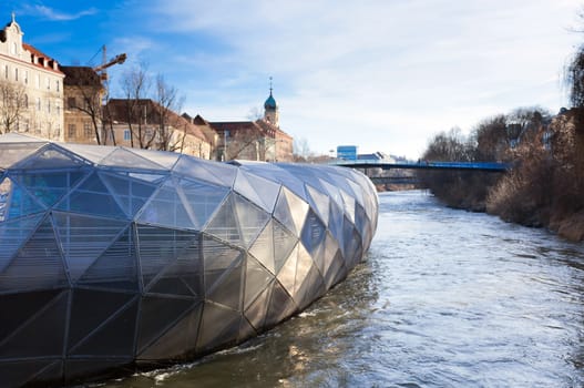 Graz, Austria - January 16, 2011: Graz city seen from Island on Mur river connected by a modern steel and glass bridge, Styria, Graz, Austria