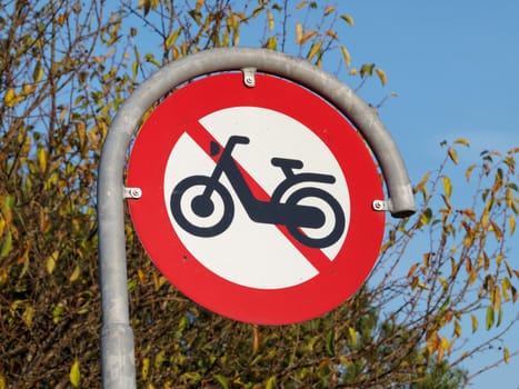 Prohibitory traffic sign the passage of  motorcycles scooters prohibited    