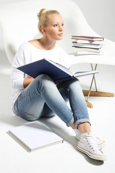 Beautiful student preparing for the exam by reading a book.