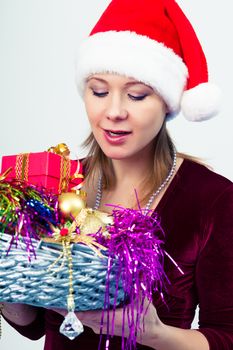 Attractive happy girl in santa hat with gift boxes