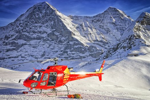 Red helicopter at swiss ski resort near Jungfrau mountain