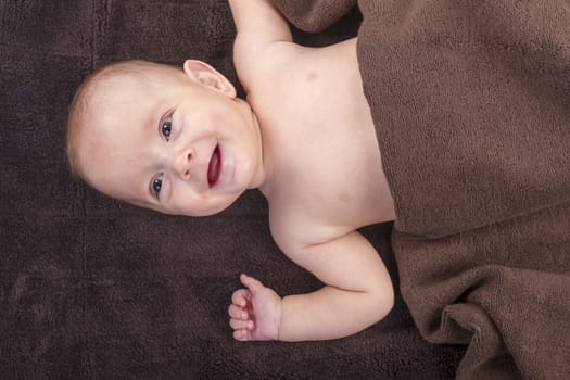 baby boy over brown blanket on white background