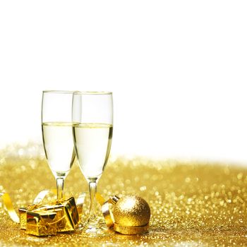 Champagne in glasses and gift box on golden background