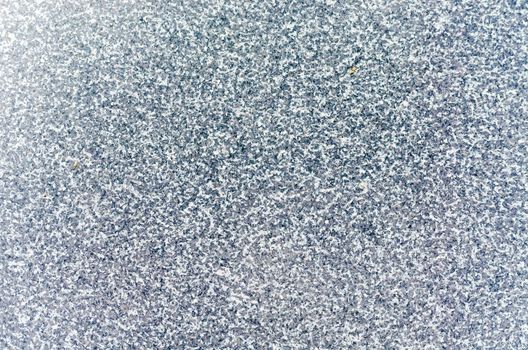 Shining detailed surface of a gray stone slab with natural clay slope. Used as background or texture.