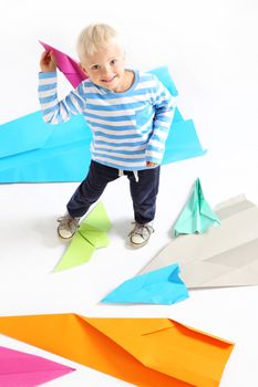 A little boy holds in his hand a paper airplane