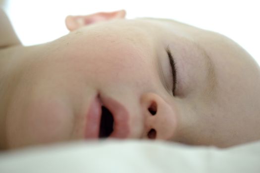 portrait of a sleeping baby, white besheet and backround