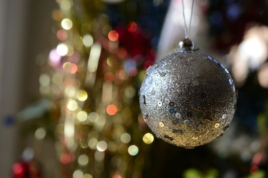 grey Christmas ball, blured sparrkly background