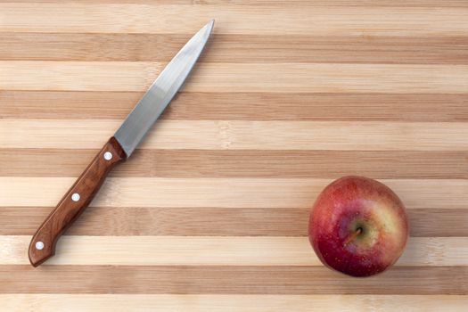 Kitchen knife with apple on the wooden board