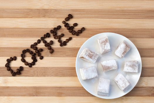 Coffee sign written with raw coffee beans on the wooden board.