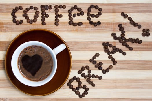 Heart in cup of coffee and raw coffee beans.